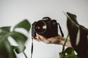 camera in hand met planten op achtergrond
